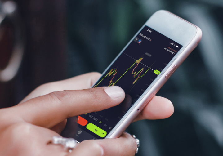 Person using a phone with FXTM Web Trader